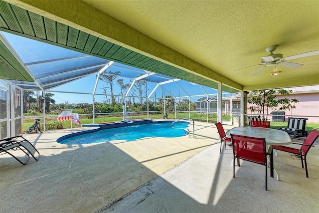 view of swimming pool featuring a patio, glass enclosure, and ceiling fan