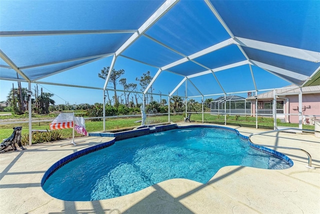 view of swimming pool with glass enclosure and a patio area