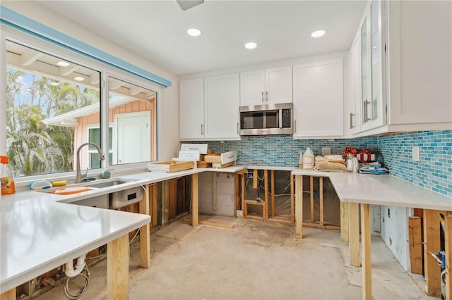 kitchen featuring sink, white cabinets, and decorative backsplash