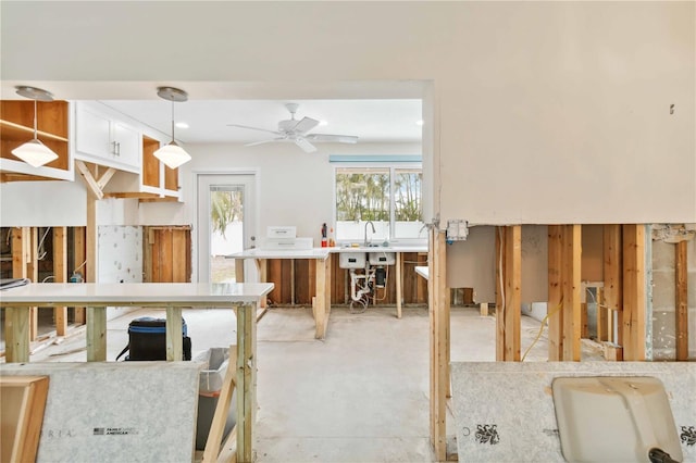 kitchen featuring white cabinets, ceiling fan, and decorative light fixtures