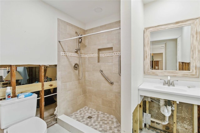 bathroom featuring sink, toilet, and tiled shower