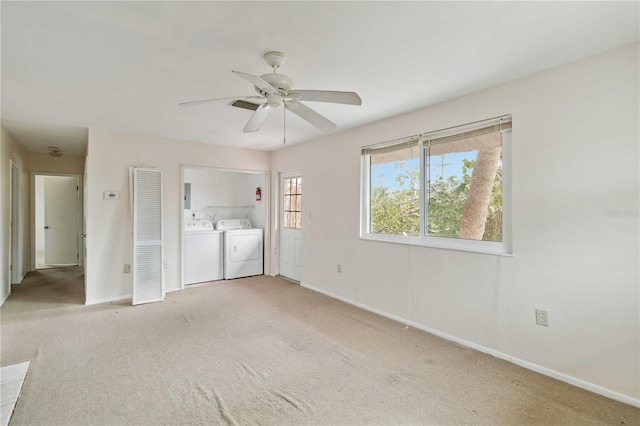 unfurnished bedroom with light carpet, washing machine and clothes dryer, and ceiling fan