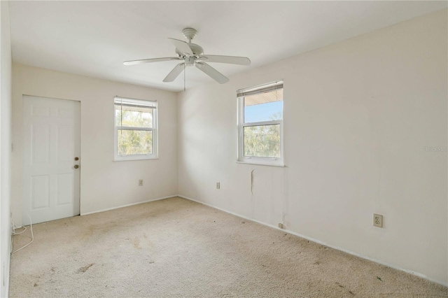 empty room featuring ceiling fan and light colored carpet