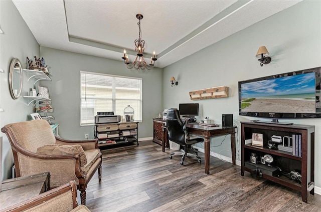 office space with dark hardwood / wood-style flooring, a textured ceiling, a raised ceiling, and a chandelier