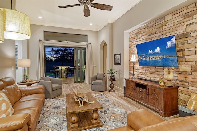 living room featuring ceiling fan, crown molding, and light hardwood / wood-style flooring