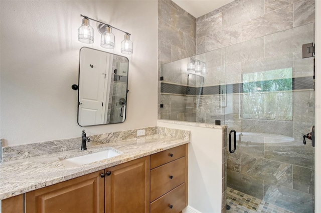 bathroom featuring a shower with shower door and vanity