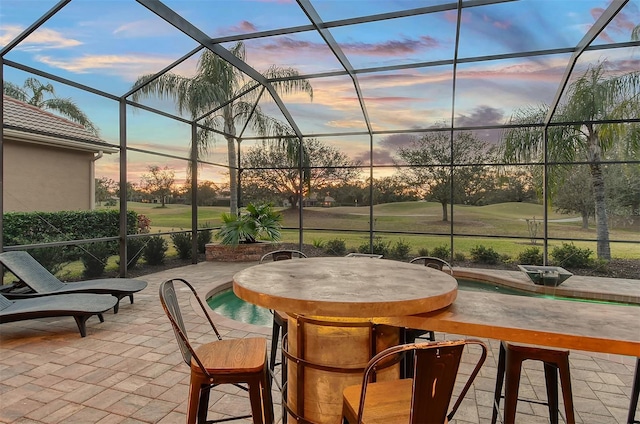 patio terrace at dusk with exterior bar and glass enclosure