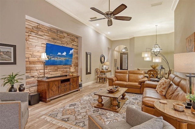 living room with ornamental molding, ceiling fan with notable chandelier, and light hardwood / wood-style flooring