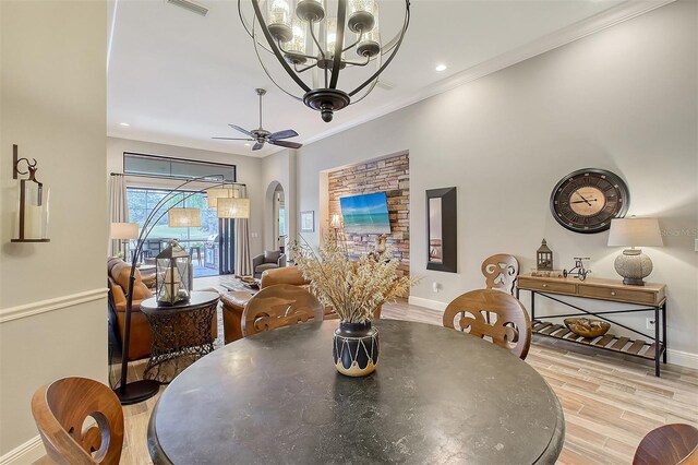 dining room featuring ceiling fan with notable chandelier, ornamental molding, and light hardwood / wood-style flooring