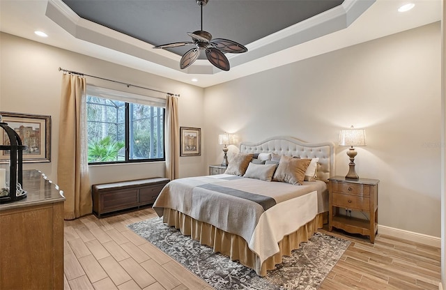 bedroom with ceiling fan, ornamental molding, and a tray ceiling