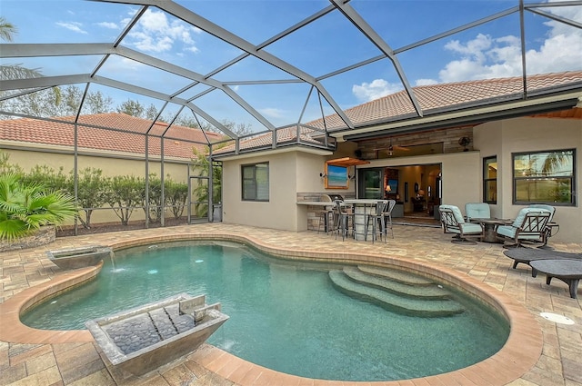 view of swimming pool featuring glass enclosure, exterior bar, pool water feature, and a patio