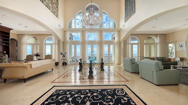 entrance foyer featuring a water view, a notable chandelier, and a towering ceiling