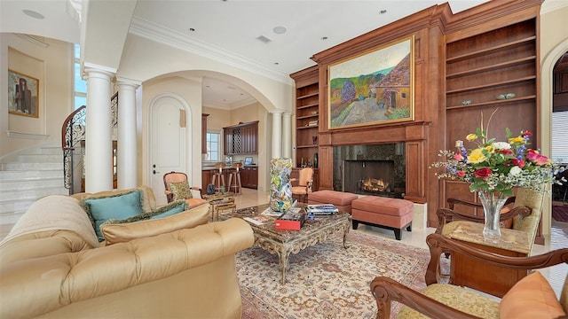 tiled living room featuring a fireplace, ornate columns, ornamental molding, and built in features