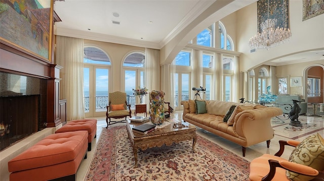 interior space with a towering ceiling, a wealth of natural light, crown molding, and a water view