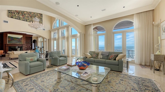 living room featuring a water view, a high ceiling, and crown molding