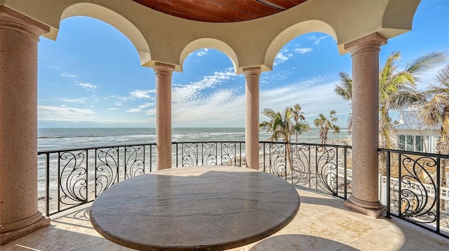 balcony featuring a water view and a view of the beach