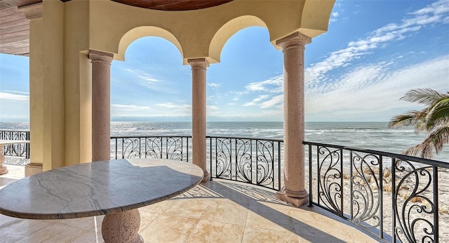 balcony featuring a water view and a beach view