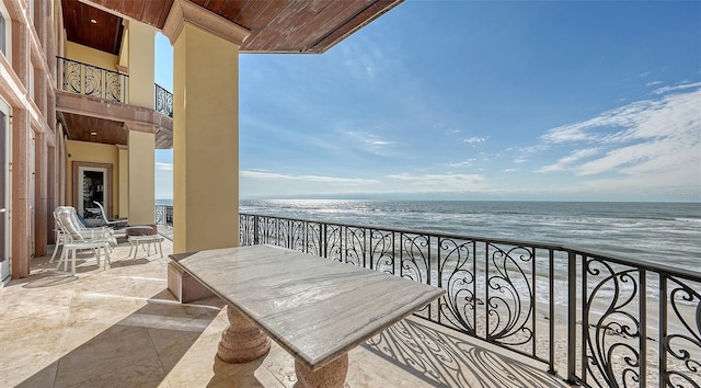 balcony featuring a water view and a view of the beach