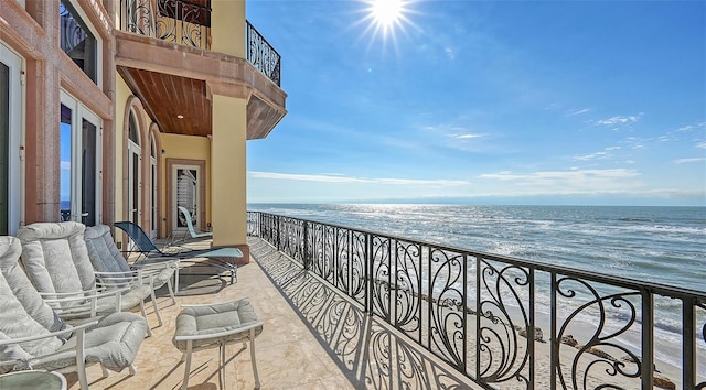 balcony featuring a water view and a view of the beach