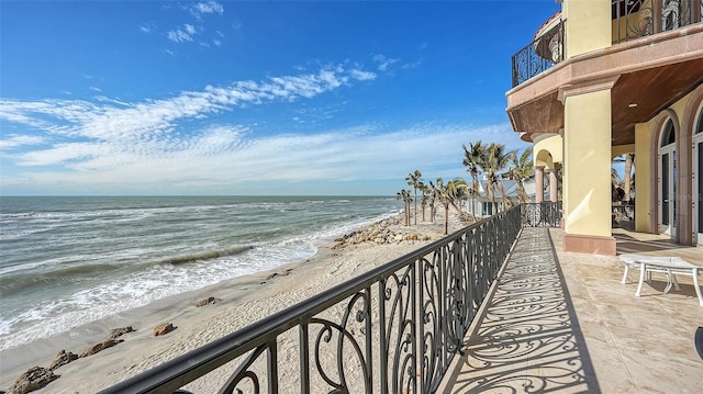 balcony featuring a beach view and a water view