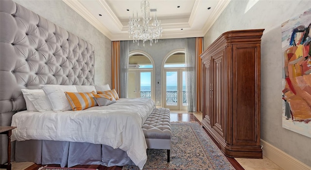 bedroom featuring a water view, access to outside, crown molding, and a raised ceiling