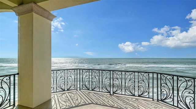 balcony featuring a view of the beach and a water view