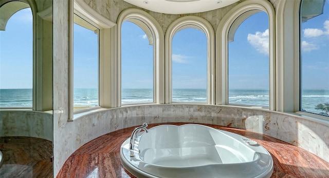 bathroom featuring a water view and a healthy amount of sunlight