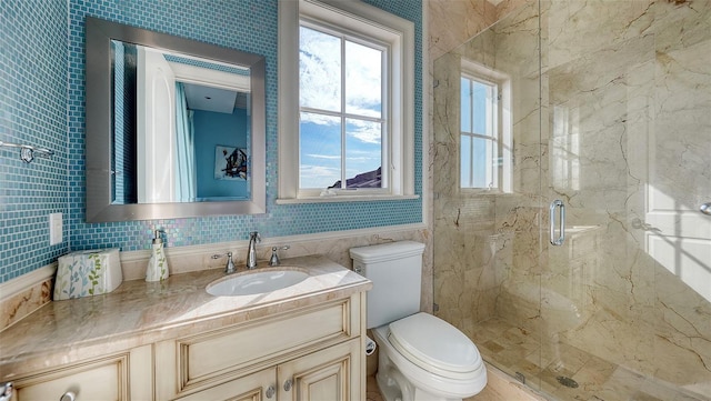 bathroom featuring toilet, a shower with door, backsplash, and vanity