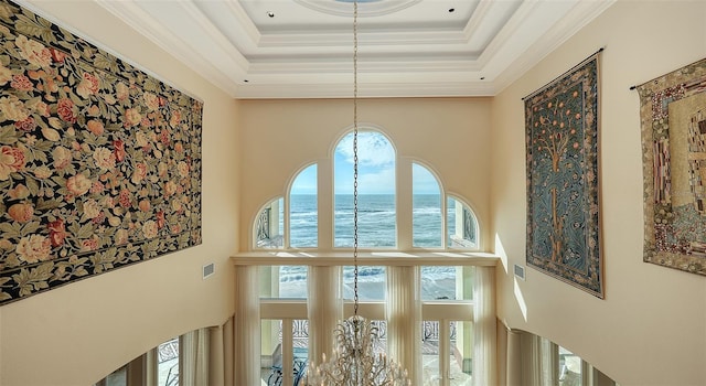 room details featuring an inviting chandelier, crown molding, and a water view