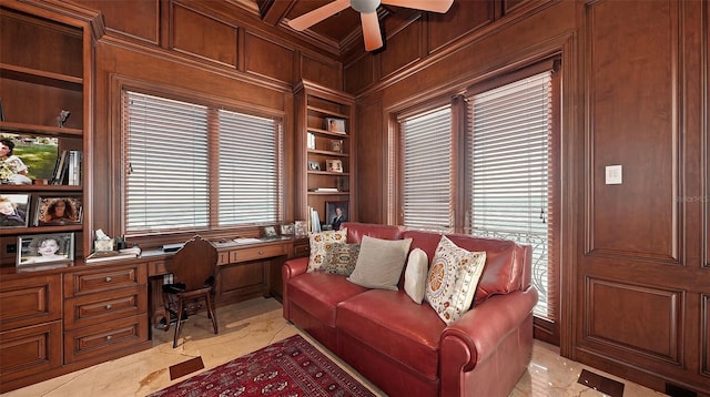 office with ceiling fan, built in shelves, a wealth of natural light, and wood walls