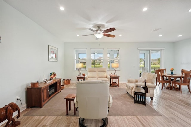 living room featuring ceiling fan and light hardwood / wood-style floors