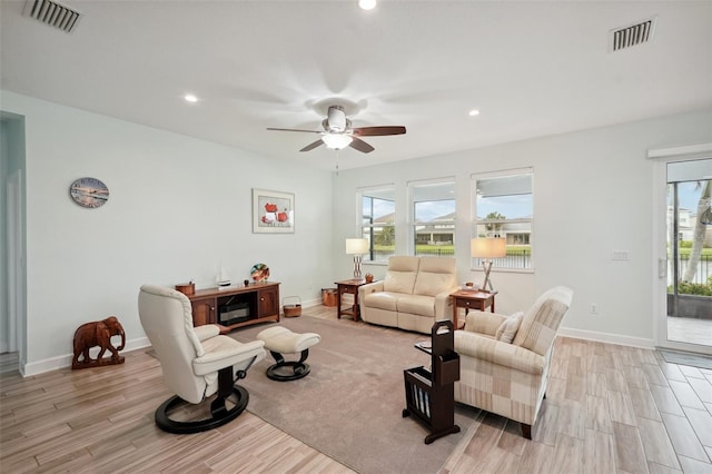 living room featuring ceiling fan and light hardwood / wood-style floors