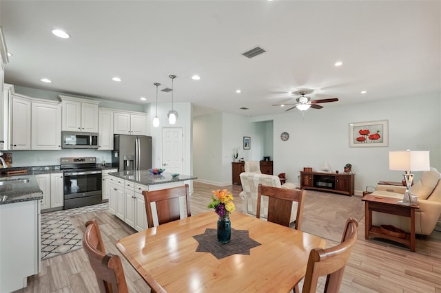 dining area with ceiling fan and sink