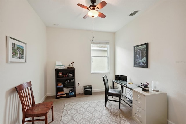 carpeted office space featuring ceiling fan