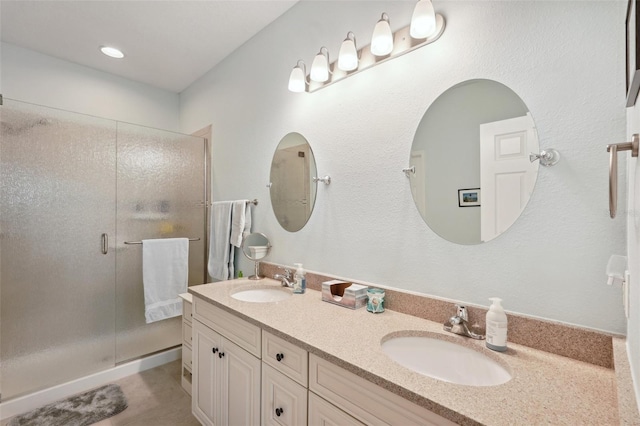 bathroom with vanity and a shower with door