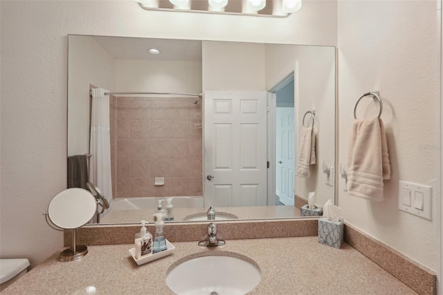 bathroom with tiled shower / bath combo and vanity