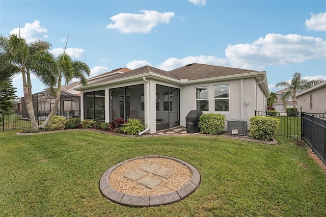 back of property featuring a sunroom, a lawn, and central air condition unit