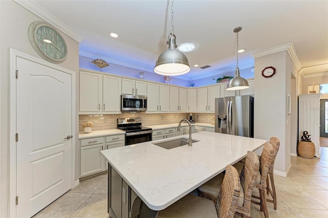 kitchen with light stone counters, an island with sink, decorative backsplash, appliances with stainless steel finishes, and sink