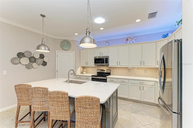 kitchen featuring stainless steel appliances, tasteful backsplash, a kitchen island with sink, white cabinets, and sink