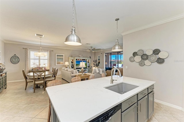 kitchen featuring a center island with sink, light tile patterned flooring, hanging light fixtures, and sink