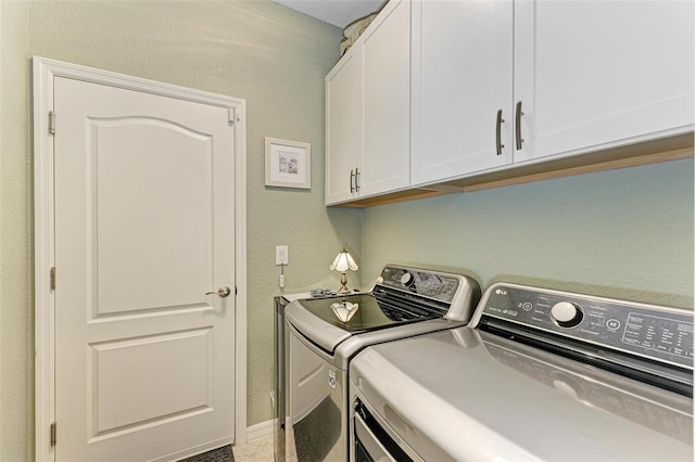 clothes washing area with washing machine and dryer and cabinets