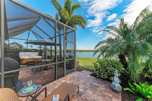 view of patio featuring a lanai, grilling area, a hot tub, and a water view