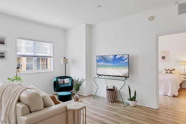 living room with light hardwood / wood-style flooring and crown molding