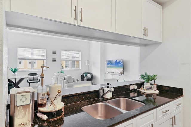 kitchen featuring white cabinets, sink, and dark stone countertops