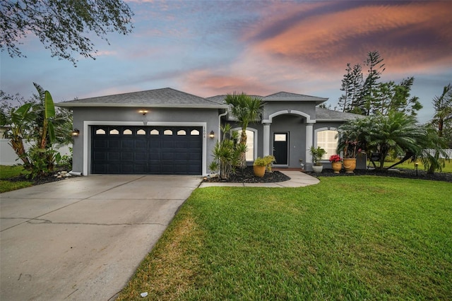 view of front of property featuring a garage and a yard