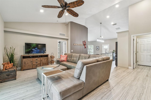 living room with ceiling fan, sink, light hardwood / wood-style flooring, and high vaulted ceiling