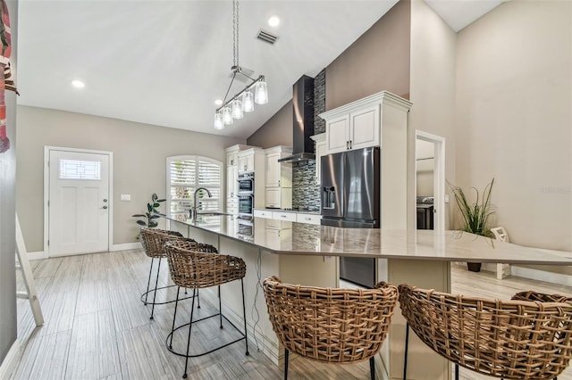 kitchen with white cabinetry, stainless steel appliances, a breakfast bar, and decorative light fixtures