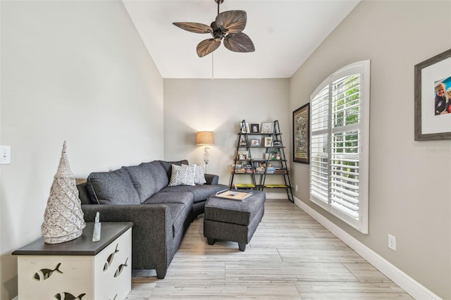 living room with ceiling fan, lofted ceiling, and light hardwood / wood-style floors