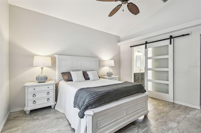 bedroom with ensuite bathroom, a barn door, ceiling fan, and vaulted ceiling