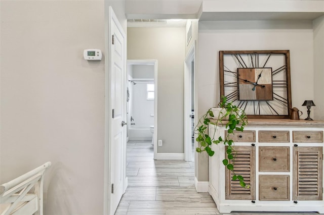 corridor with light hardwood / wood-style floors